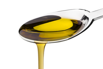 Olive oil poured from a spoon isolated on white