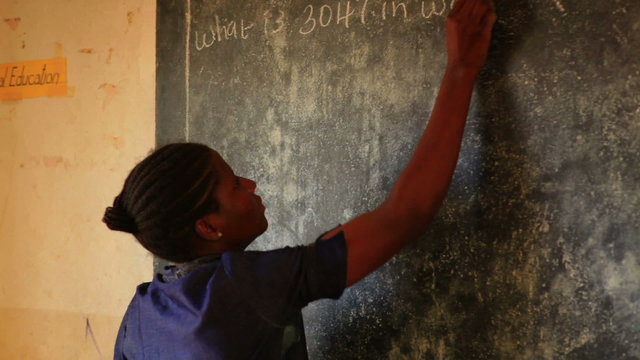 Teacher and a chalkboard in Kenya.