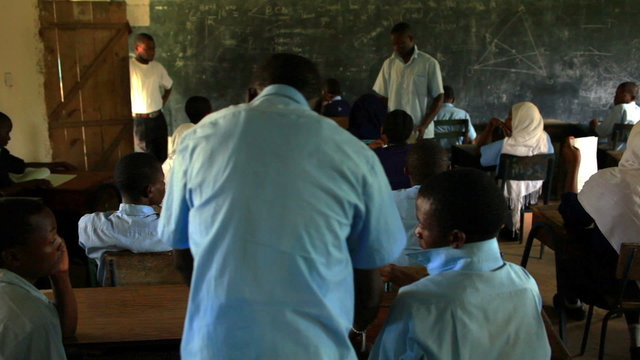 Students taking a test in a classroom in Africa.