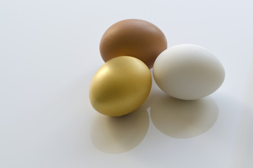 Drei Eier isoliert (braun, weiß, gold)