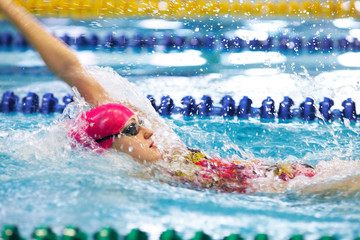 Young girl floating on her back in the pool