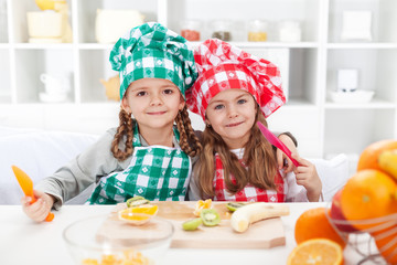 Little chefs slicing fruits in the kitchen