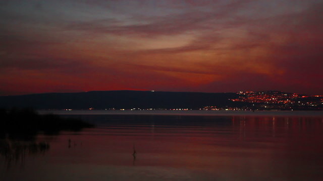 Stock Video Footage of city lights and a colorful sky at the Sea of Galilee in Israel.