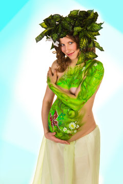 Pregnant woman with body-art with green leaves
