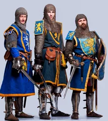 Photo sur Aluminium Chevaliers Trois chevaliers médiévaux isolés sur fond gris.