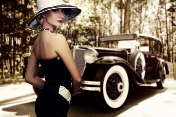 Woman in hat against retro car.