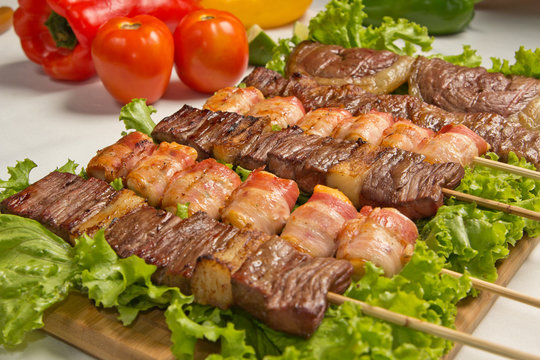 Bife de churrasco no espeto sobre fundo preto gastronomia brasileira