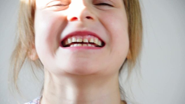 Close-up portrait of a happy little girl bursting in laugh