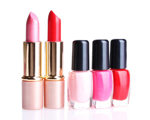 bright lipsticks and nail polishes isolated on white