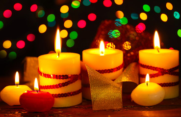 Beautiful candles on wooden table on bright background