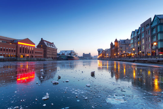 Old town in Gdansk with frozen Motlawa river at dusk, Poland