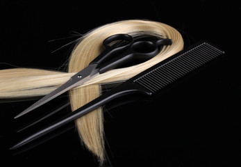 Shiny blond hair with hair cutting shears and comb isolated