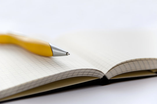 Yellow pen and notebook on the white background