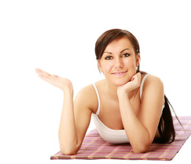 Fototapeta premium Young sportive girl lying on the mat and holding something