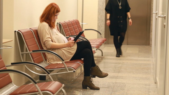 girl in pregnent in the firm with tablet