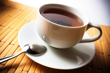 cup of tea in a white cup on a bamboo background