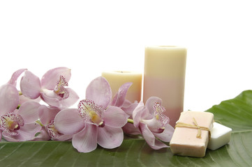 pink orchid and candle with soap on banana leaf