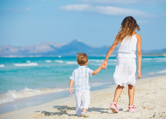 Young girl and boy playing happily at pretty beach