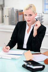 Blonde businesswoman writing a report