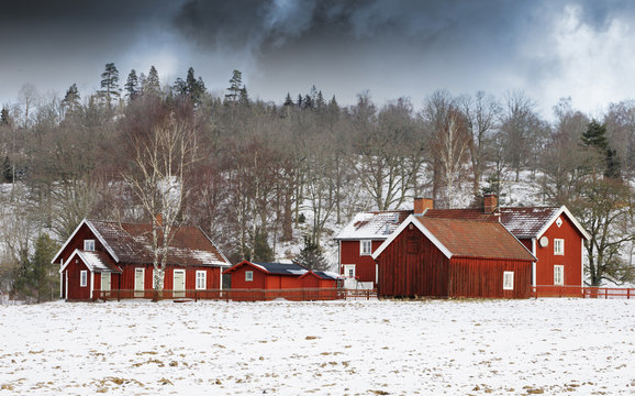 small farm in winter, storm clouds approaching