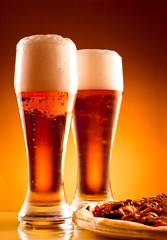 Two glass of beer and pizza over yellow background