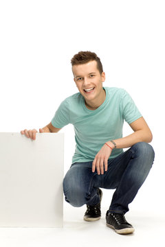 Young man holding blank placard