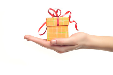 female hand holding red and yellow gift box with a bow isolated