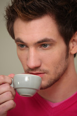 A serious man drinking a cup of coffee