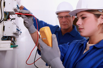 Tradeswoman using a multimeter