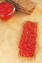 Caviar and crisps on wooden background