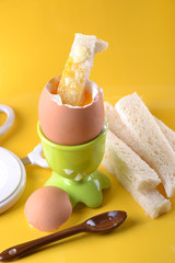 Oeuf à la coque bio et mouillettes sur fond jaune