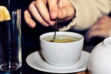 the guy is mixing a teaspoon of green tea