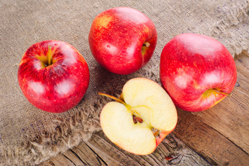 Ripe apple fruits on old wooden table with canvas tablecloth