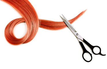 Shiny red hair and hair cutting shears isolated on white