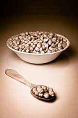 Chickpeas in a bowl and wooden spoon. Retro.