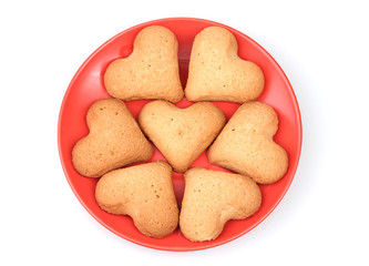 Heart-shaped cookies on red saucer isolated on white
