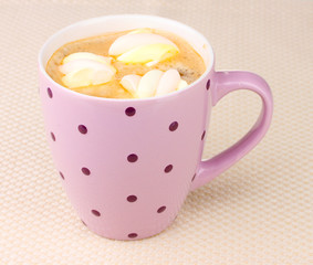 Cup of cappucino with marshmallows on beige background