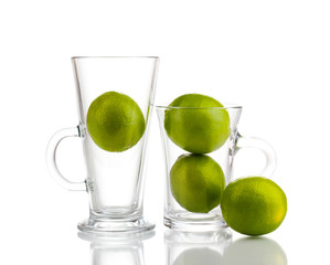 Fresh limes in glass cups isolated on white