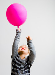 kind spielt mit dem Luftballon