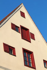 Fototapeta na wymiar Dwuspadowy dom z czerwonym okien