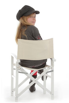 fillette posant avec v&ecirc;tements hiver sur chaise r&eacute;gisseur
