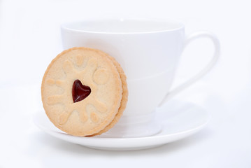 White cup and cookie on the saucer on the white background