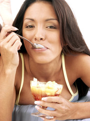 Mujer hispana comiendo helado de frutas.