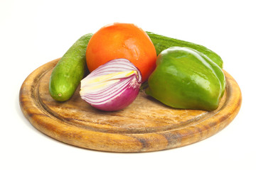 Pepper, onion, cucumber and tomato on a desk