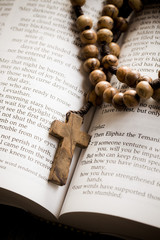 wooden rosary on the open Bible