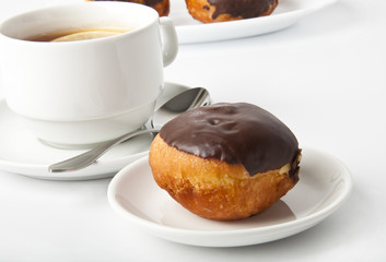 donut with chocolate and a cup of tea on a white background
