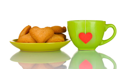 Green cup with tea bag and heart-shaped cookies