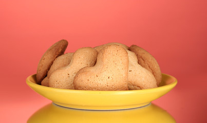 Heart-shaped cookies on yellow plate on red background