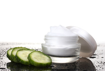 cream and fresh sliced cucumber on table isolated on white