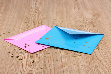 Color envelopes and confetti on wooden background